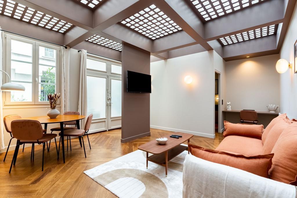 Séjour avec verrière, parquet et canapé terracotta